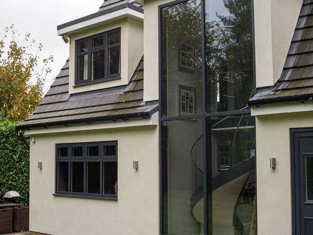 Close up of rear curtain walling and casement windows, contrasting well against the off white render.