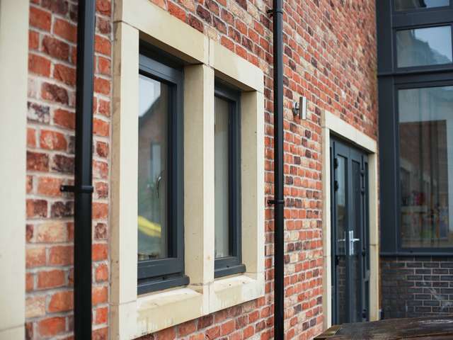 Close up of aluminium windows set it stone surrounds.