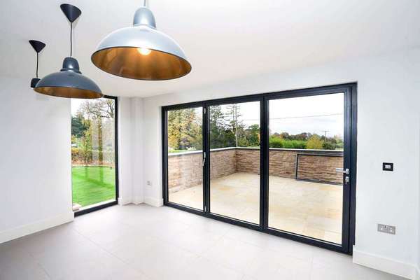 Close up of grey aluminium bifold doors.
