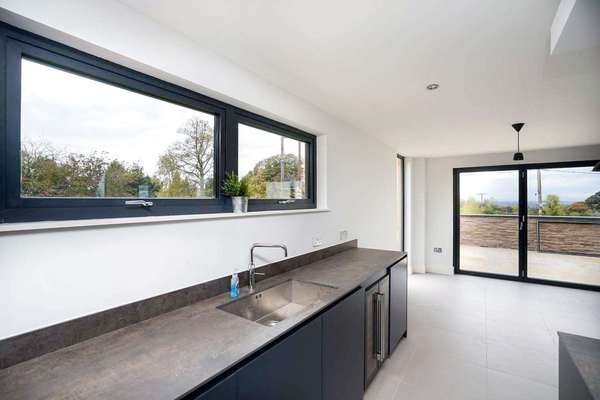 Internal view of open plan living space highlighting the dual opening aluminium window.
