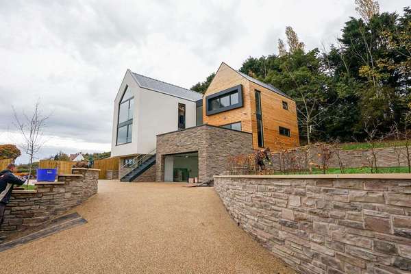 Corner shot of new build development featuring a range of aluminium products including bifolds, windows and doors.
