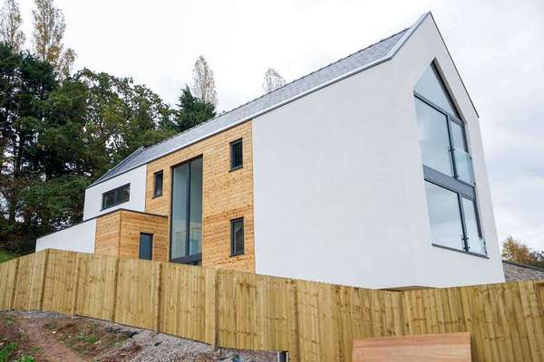 SIde view showing a range of smaller aluminium windows as well as a large central curtain walling system, making a real feature of the internal staircase space.
