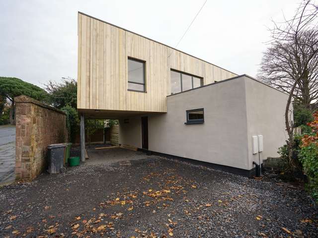 Main shot of property showing canterlievered  top floor with Rationel windows throughout, and aluminium entrance door.