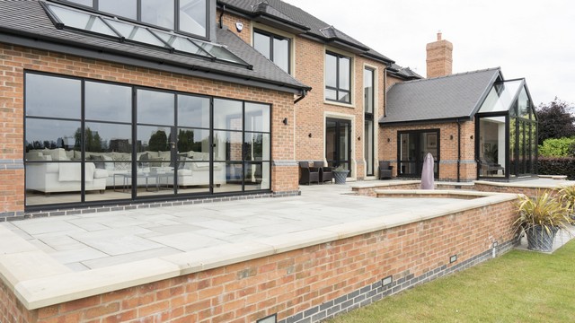 Angled view of the home highlighting the stunning glazed area, Crittall doors and various aluminium windows.