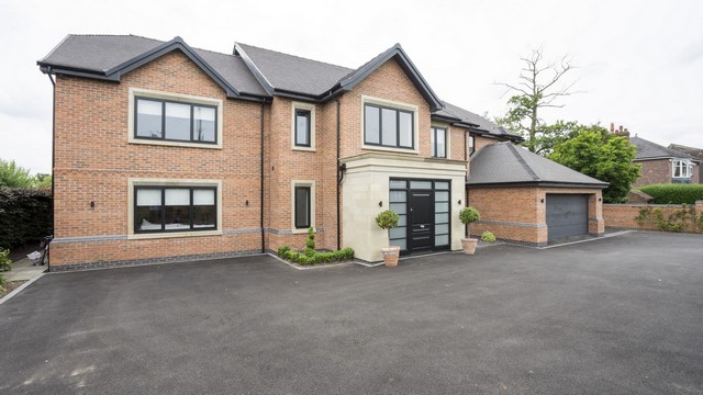 The front of this super home with lots of large aluminium windows.