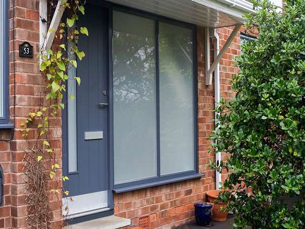 Close up of Rationel panelled entrance door with dual sand-blasted side lights.