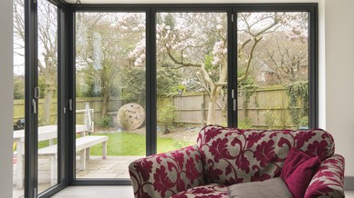 Internal view of the corner bifolding doors in RAL 7016 grey, 3 and 2 panel bifolding door sets have been used with a sliding corner post to create a fully open corner within the building.