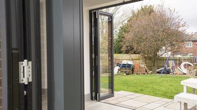 Close up detail of the hinges and aluminium profile of this stunning set of aluminium bifolidng doors.