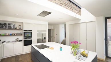 Overview of this stunning family kitchen space showing how the rooflight connects the new extension to the original building, this detail makes the back wall of the original house look as if it is floating freely above the kitchen island. A stunning detail that certainly adds the wow factor.