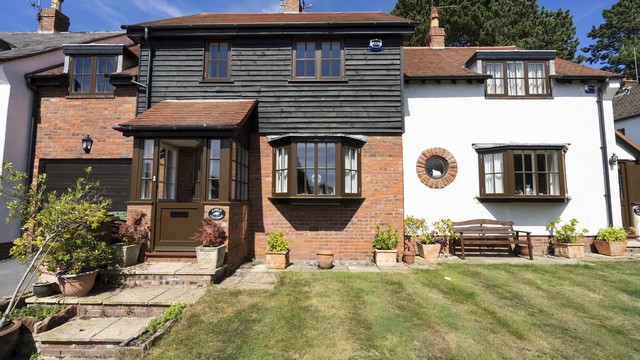 Front of house view with traditional style Rationel alu-clad windows in brown installed throughout with matching doors.